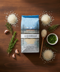 Acquerello rice package on a wooden surface with rice and herbs around