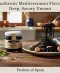 Black squid ink pasta with shrimp on a plate next to a jar of cuttlefish ink, set against a kitchen backdrop.