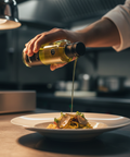 Person pouring olive oil over a dish of pasta in a kitchen setting