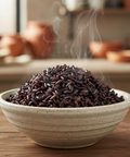 Bowl of steaming black rice on a wooden surface