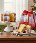 Bundt cake with powdered sugar on a white plate, next to a bag of Bundt cake mix with a red ribbon, on a wooden table with Christmas decorations.