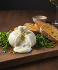 Bocconcini cheese with arugula and bread on a wooden board