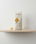 Bag of pasta on a wooden shelf against a white wall