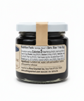 Jar of black spread with a white lid on a white background
