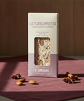 La Torronfetta chocolate bar packaging on a red fabric background with star anise.