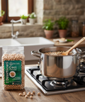 Cooking ceci (chickpeas) in a pot on a stove with a package of Del Colle chickpeas next to it.