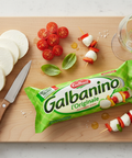 Wooden cutting board with sliced mozzarella, cherry tomatoes, basil leaves, skewers, and a package of Galbanino mozzarella on a light gray background.