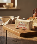 Butter block with 'Il Parco' branding on a wooden cutting board with bread in the background.
