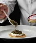Person adding caviar to a dish with a spoon