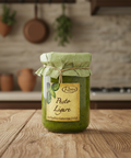 Jar of pesto Ligure on a wooden surface with a kitchen background