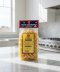 Packaged pasta on a kitchen counter with a window and stove in the background