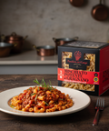 Pasta dish on a plate with a box of pasta in the background