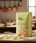 Packaging of gnocchi on a kitchen counter with utensils in the background