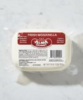 Block of fresh mozzarella with Alma Gourmet label on a marble surface
