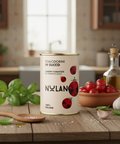 Can of Nulano cherry tomatoes on a kitchen counter with tomatoes and basil in the background