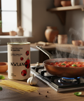 Nulan tomato sauce can on a kitchen counter with a pan of boiling tomatoes and pasta ingredients.