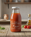 Bottle of Contadini tomato sauce on a wooden table with tomatoes and basil in the background.
