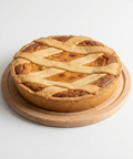Pie with a lattice crust on a wooden board against a white background