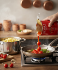 Person pouring Rojalo tomato sauce into a pan on a stove with pasta in the background