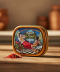Alma Gourmet Spanish Saffron tin on a wooden surface with saffron strands in front
