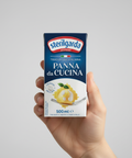Hand holding a box of Sterilgarda Panna da Cucina against a gray background