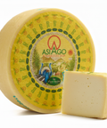 Round Asiago cheese with a piece removed on a white background
