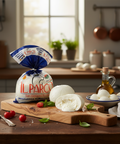 Il Parco mozzarella on a wooden cutting board with tomatoes and a kitchen background
