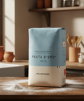 Pasta D'Oro package on a wooden table with a kitchen background