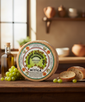 Wheel of Parmigiano Reggiano with a decorative label on a wooden surface with grapes and bread.